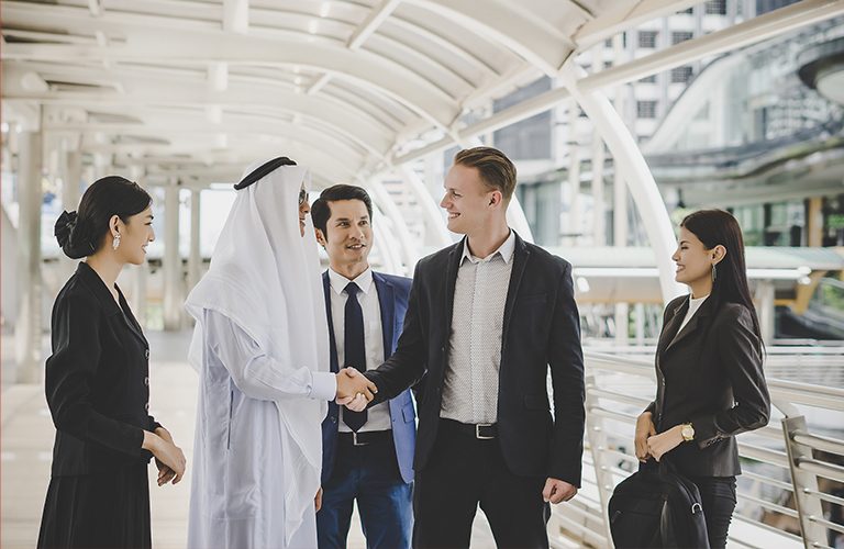 Man and woman with traditional clothes working in a business office of Dubai. Portraits of  successful entrepreneurs businessman and businesswoman in formal emirates outfits. Concept about middle eastern cultures, lifestyle and professional occupations